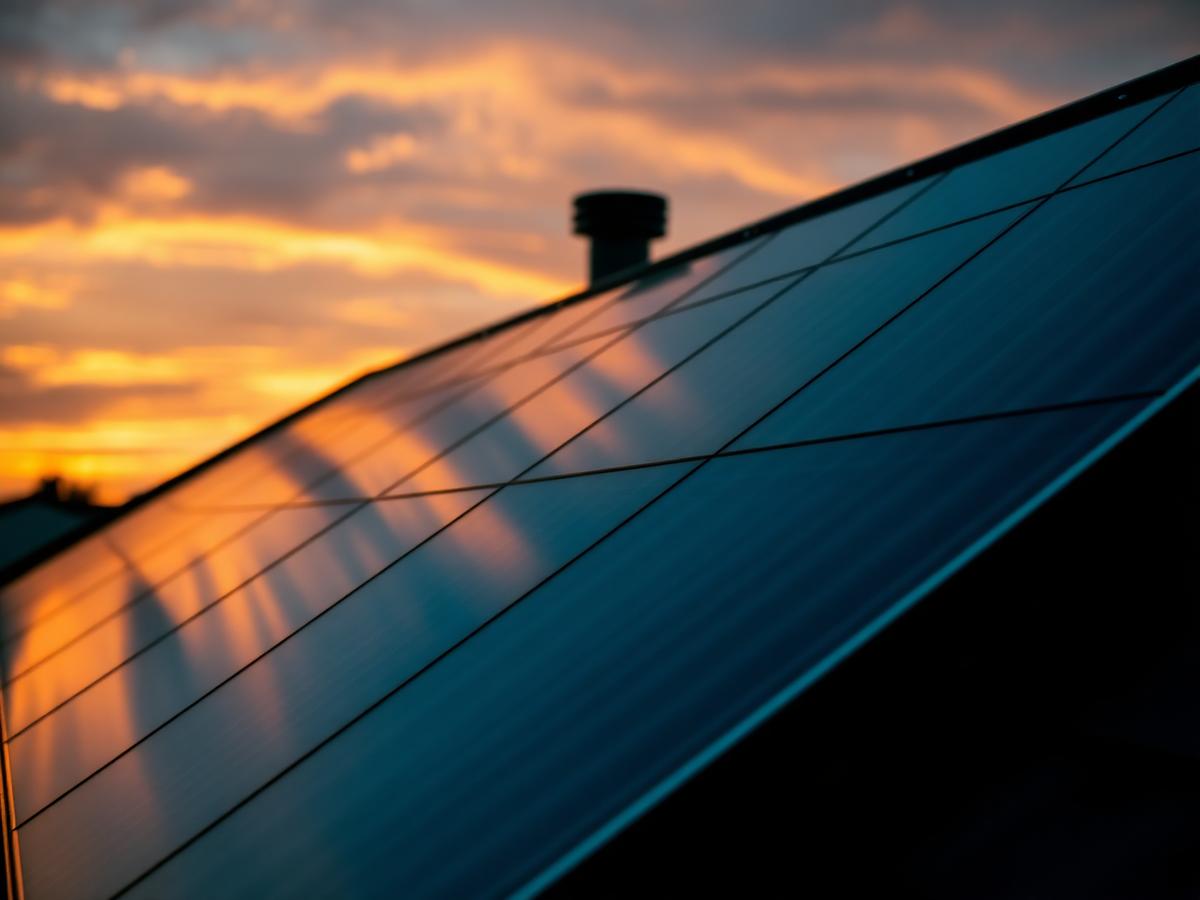 Technicians installing photovoltaic solar panels on a rooftop